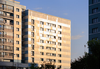 Modern buildings, walls and windows, reflections and sun rays. City view on a sunny day. 