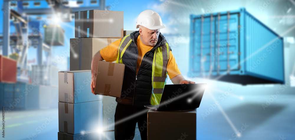 Poster dock worker with helmet and safety vest checks cargo data on laptop while handling boxes. port logis