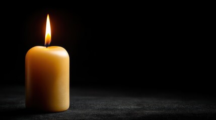 Single burning candle on dark background for relaxation and ambiance