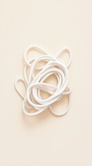 Fototapeta premium Tangled white charging cable photographed from above, creating abstract loops on a minimal beige background with soft shadows and modern tech symbolism.