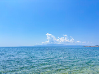 seascape of a calm adriatic sea off chalkidiki greece with a mountain on the horizon and a large...