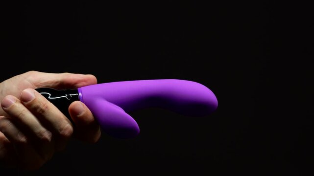 Purple rabbit vibrator for sexual pleasure and enjoyment.
Hand vibrator for orgasm on black isolated background.
Adult sex toys