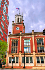 Under dramatic clouds, the red brick Manchester City Hall stands on Elm Street in Manchester, New...