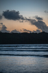 Silhouette of three fishermen standing in the Arabian Sea at Caranzalem Beach, Goa, during monsoon...