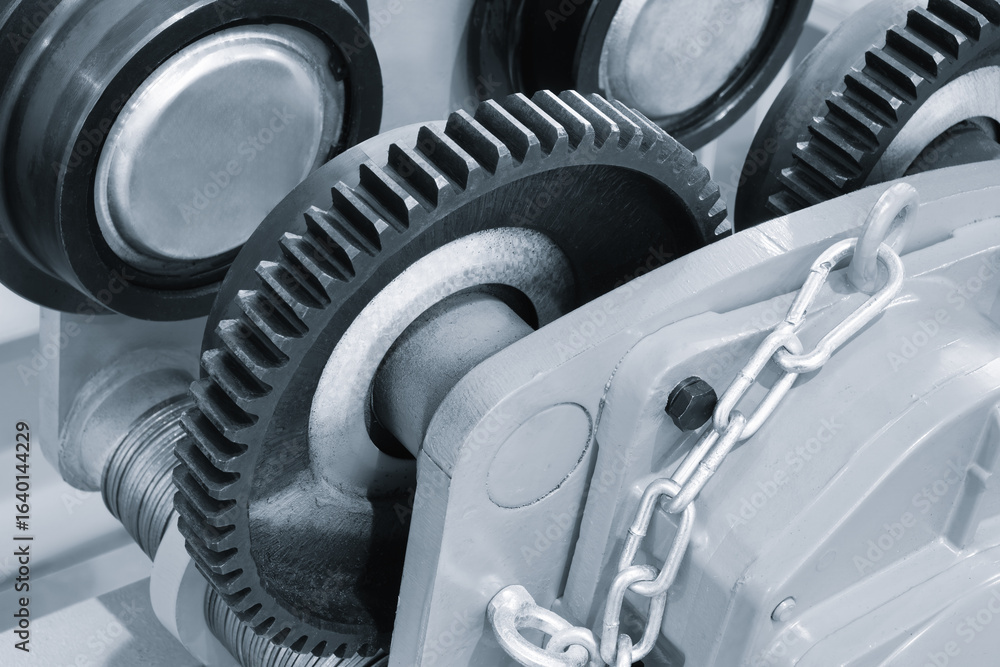 Poster a close up of a gear with a silver and black color. the gear is part of a machine and is in the midd