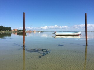 Obraz premium Traditional fishing boats floating on calm water under blue sky