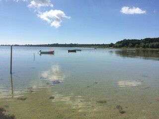 Clear blue sea with anchored boats under sunny sky