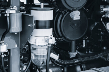 Shown is a large engine with many tubes, bolts and various parts. Auto service concept background