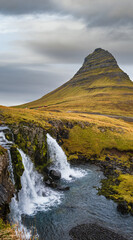Famous picturesque Kirkjufell mountain and Kirkjufellsfoss waterfall next to Grundarfjörður at West Iceland autumn view.