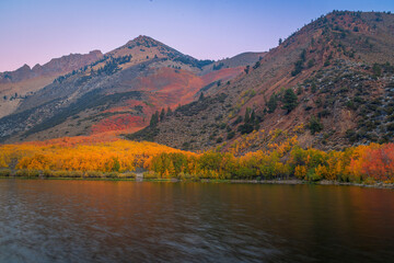 Obraz premium Colorful autumn landscape in sunrise at North lake, Bishop, California, alpine lakes, vivid fall foliage, and dramatic Sierra Nevada mountain reflections under a deep blue sky.