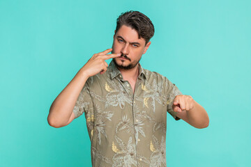 Middle-aged man points two fingers to his eyes and then forward, expressing control, attention or...