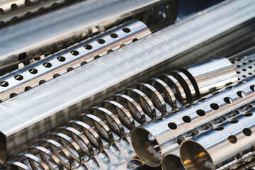 A bundle of metal pipes with holes. The pipes are of different sizes and shapes. The concept is of...