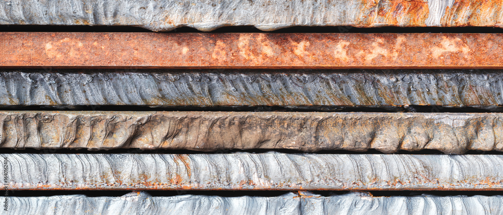Poster stack of thick heavy metal plates rusty uneven surface after laser cutting. plates stacked top each 