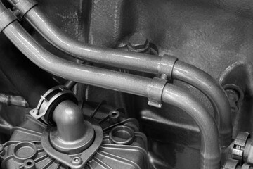 Shown is a large engine with many tubes, bolts and various parts. Auto service concept background.