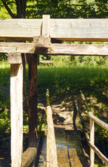 Naklejka premium Wooden structures serving as a water drive for the industrial part of buildings with mill wheels. Water drive structure for mill wheels.