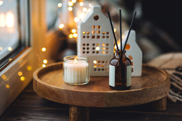 Idea how to create cozy holiday atmosphere and Christmas mood at home. Aromatherapy, aroma reed diffuser with sweet scent of cinnamon, anise, vanilla, faire lights, cute ceramic chandelier houses