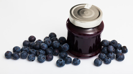 Homemade blueberry jam and fresh ripe blueberries on white background. Concept of healthy and diet food