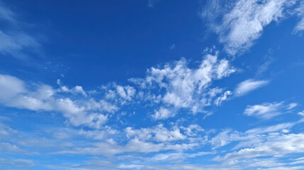 Fototapeta premium A vibrant blue sky fills the frame, adorned with various clouds drifting lazily. This scenic view captures a serene midday atmosphere, perfect for a peaceful day outdoors.