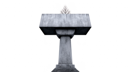 Modern concrete sculpture featuring large, flat top supported by sturdy base, with small tree growing from top, symbolizing nature resilience