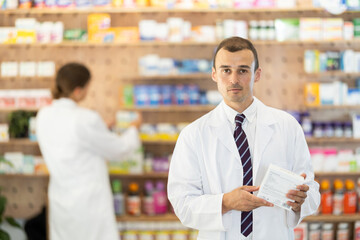 Man pharmacist holds out box, remedy for solving skin problems, eliminating defects. Selection of therapeutic cosmetics and care products according to problem