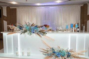 Elegant Wedding Bar Setup with Blue Floral Arrangements and Pampas Grass, White Drapery, Modern...