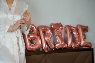 Bride Getting Ready with Champagne and Balloons: Luxury Wedding Preparation Scene with Rose Gold...