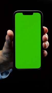 Green screen on mobile phone on isolated black background in male hand.
Replacement of background for commercial use
Smartphone, screen, chromakey, helen, technology