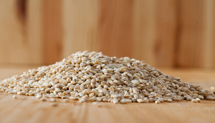 Obraz premium Pearl barley on a wooden surface, macro