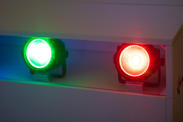 Green and red colored lights on a white surface
