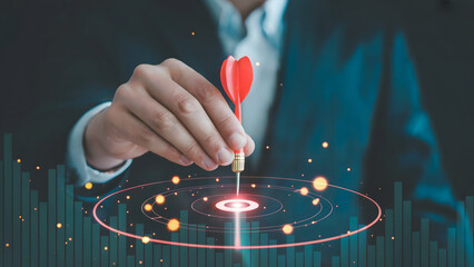 Professional achieving business success by focusing on goals and targets with red dart aimed at the center of the target with performance growth chart