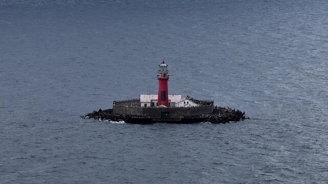 Aerial view of Kolka Lighthouse standing on a small fortified island in the Baltic Sea, surrounded by open water and seabirds, serving as a maritime navigation aid off Latvia&rsquo;s coast.