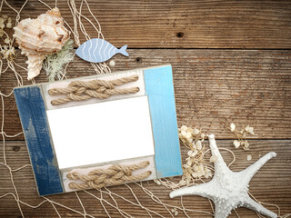 Beach coastal image with transparent picture photo frame painted blue and rope knots on a rustic...