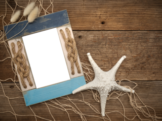 Beach coastal image with transparent picture photo frame painted blue and rope knots on a rustic old wood table, fishing fishnet netting, shells, ocean sea themed decorations. Customize DIY
