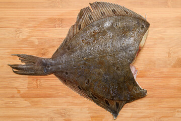 Thawed headless flounder on a cutting board.