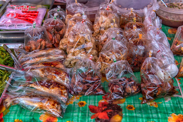A street market with a range of ready-made food in plastic bags.  