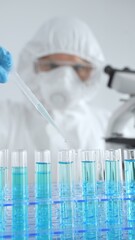 Scientific researcher wearing protective gear, carefully pipetting liquid into test tubes while...