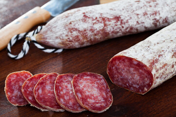 Homemade dry sausage Longaniza on wooden board