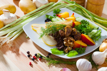 Dietary salad with chicken hearts, slices of peach, pear and roasted cheese