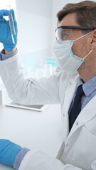 Scientist in a white lab coat, face mask, and gloves, analyzing a blue liquid in a test tube within...