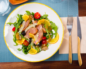 Appetizing poultry salad with duck breast, fresh greens and tomatoes