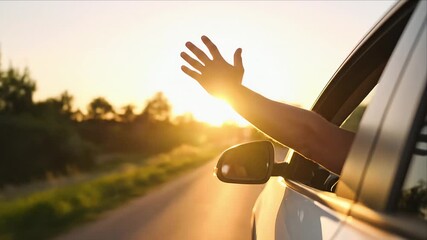 Person reaches out of car window sunset