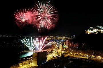 Nocturne aerial view of the fireworks launched in the beach of El Postiguet, in the Mediterranean city of Alicante, Spain.