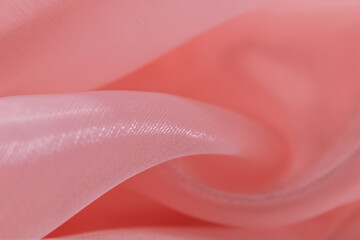Shiny pink silk fabric with flowing folds and smooth texture, creating a luxurious and feminine...