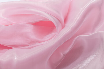Close-up of light pink translucent fabric with soft folds and smooth texture, ideal for backgrounds, fashion branding, wellness visuals, romantic themes, and elegant minimalist design compositions