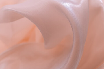 Soft translucent pink fabric with glossy surface and flowing folds, reflecting light gently and...