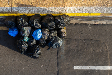 Top view of the plastic bags of trash on sidewalk in brazilian city