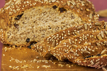 Freshly baked homemade bread in the foreground, made with a variety of whole grains