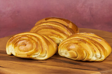 Colorful freshly baked homemade bread rolls on a wooden board with copy space in the foreground