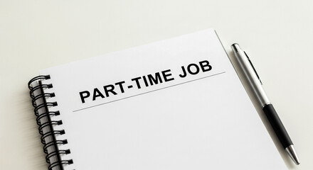 A close-up shot of a spiral-bound notebook open to a page with the words 'PART-TIME JOB' clearly written A sleek pen rests beside it suggesting planning and action