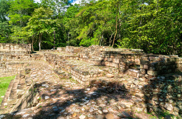 The remains of ancient Mayan structures surrounded by lush jungle at the Copan archaeological site, a UNESCO World Heritage site in Honduras